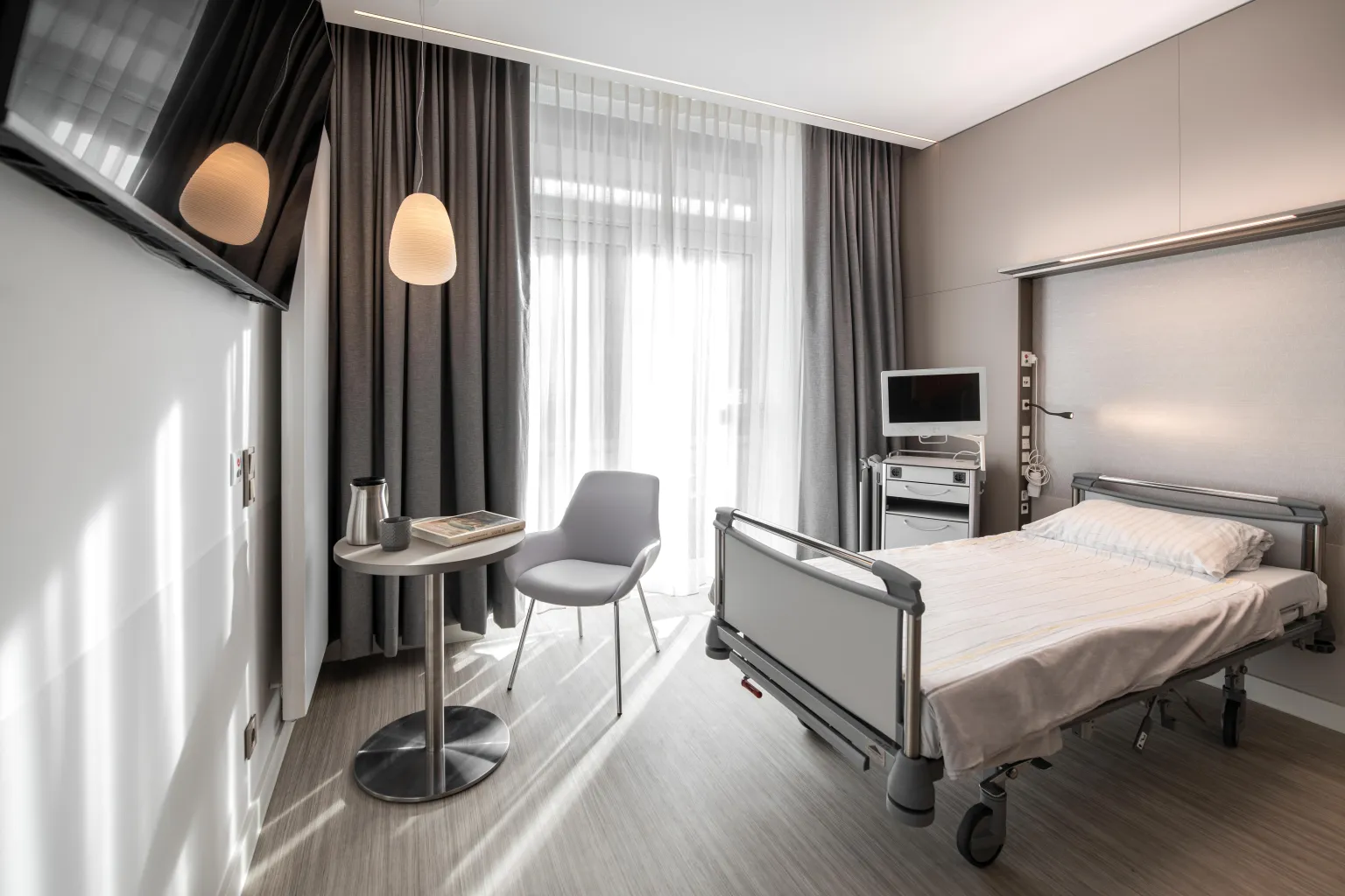 Im Hintergrund sieht man eine medizinische Vorwandversorgungseinheit in einem Patientenzimmer